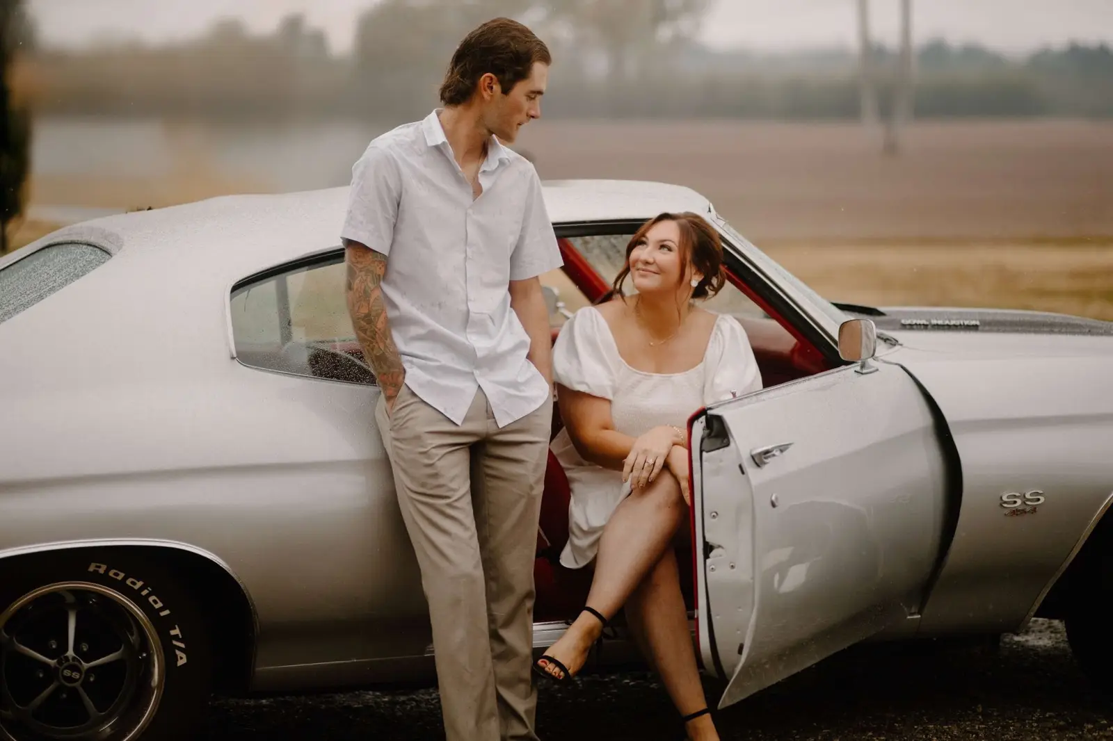 Couple posing with Sylvia, the silver 1970 Chevelle SS, during a photo session